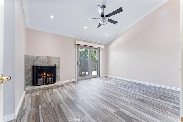 unfurnished living room featuring ceiling fan, ornamental molding, light hardwood / wood-style floors, and a high end fireplace