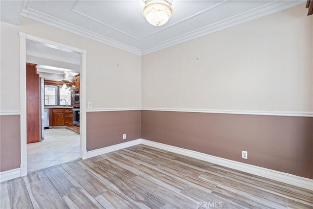 spare room featuring ornamental molding, sink, and light hardwood / wood-style flooring