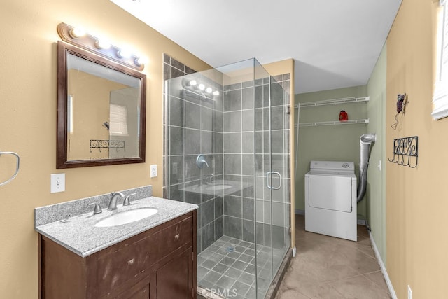 bathroom featuring washer / clothes dryer, an enclosed shower, vanity, and tile patterned floors