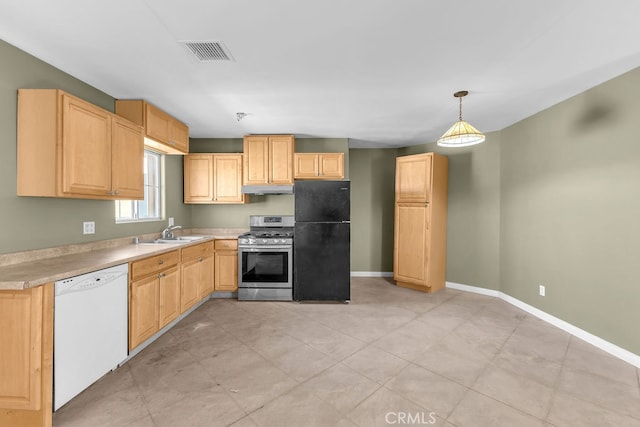 kitchen with appliances with stainless steel finishes, light brown cabinetry, pendant lighting, and sink