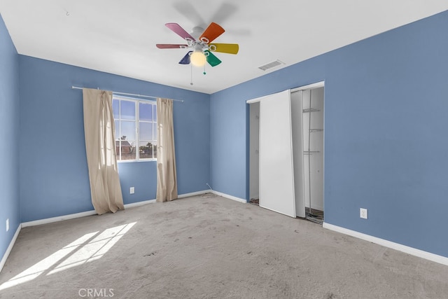 unfurnished bedroom featuring ceiling fan, a closet, and light carpet