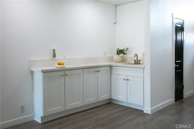 interior space with dark hardwood / wood-style flooring, white cabinets, and sink