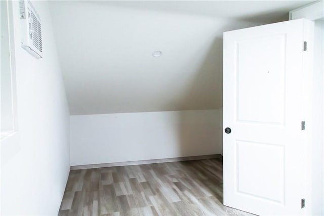 bonus room featuring light wood-type flooring and lofted ceiling