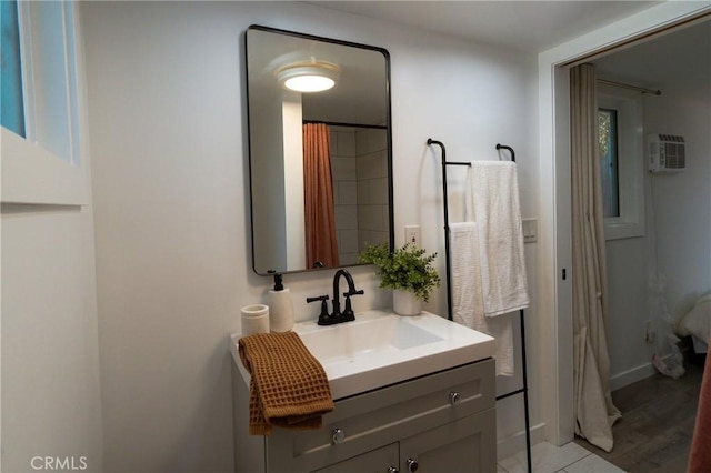 bathroom featuring hardwood / wood-style floors, vanity, a shower with shower curtain, and a wall unit AC