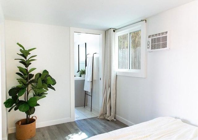 bedroom with a wall unit AC and light wood-type flooring