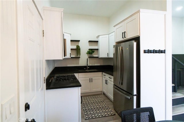 kitchen featuring white cabinets, stainless steel fridge, and sink