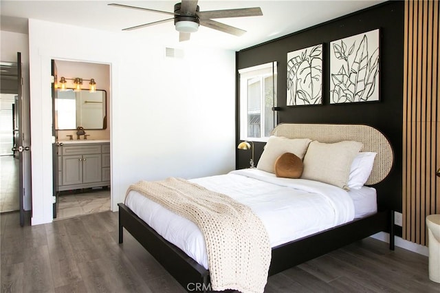 bedroom with dark hardwood / wood-style floors, ceiling fan, sink, and ensuite bath