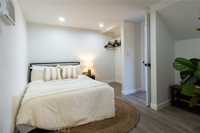 bedroom featuring an AC wall unit and wood-type flooring