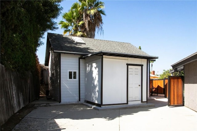 back of house with a shed and a patio