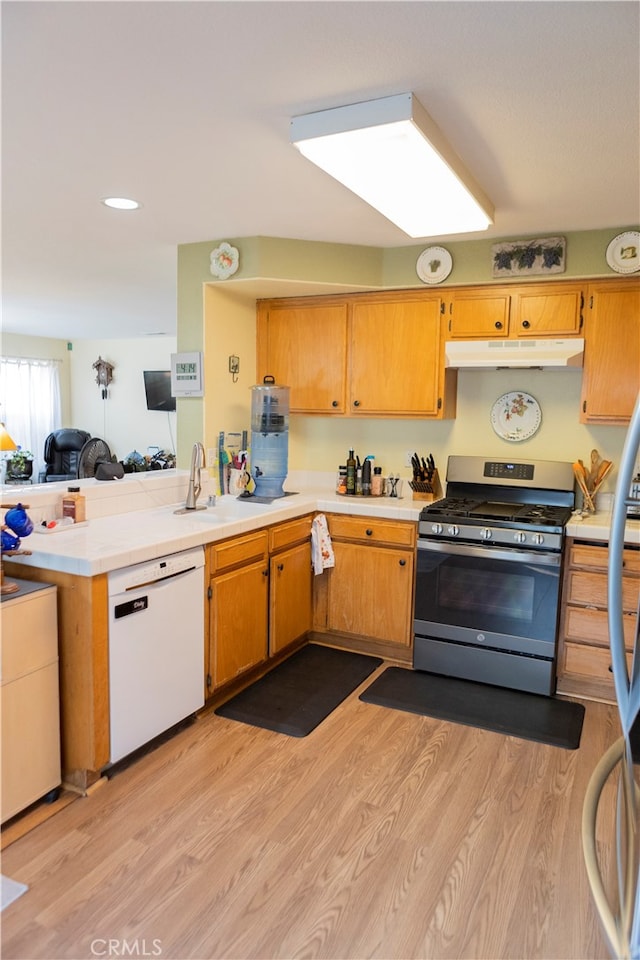 kitchen with dishwasher, sink, kitchen peninsula, light hardwood / wood-style flooring, and gas range