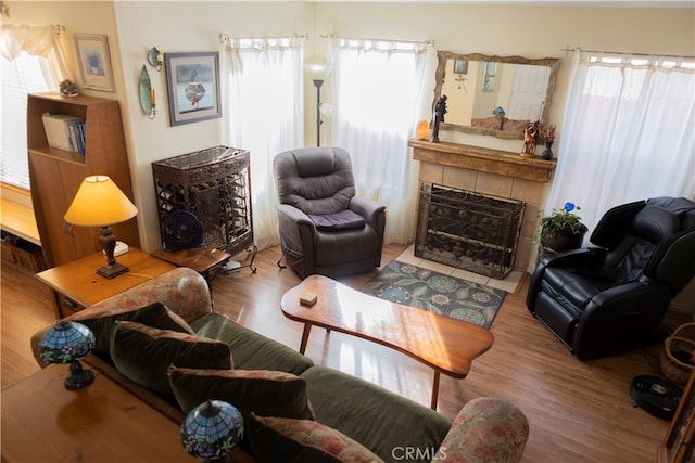 sitting room with wood-type flooring and a tiled fireplace