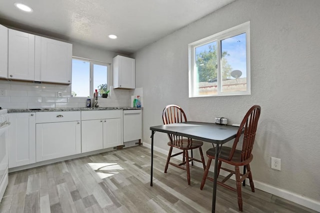 kitchen featuring a healthy amount of sunlight, white cabinetry, and decorative backsplash