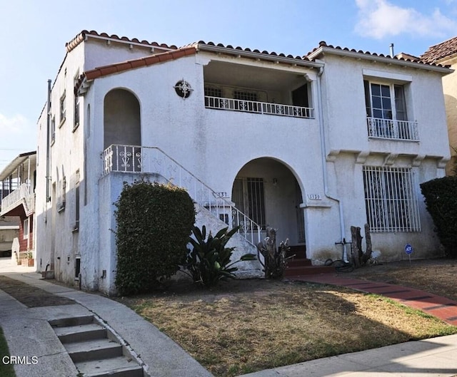 1129 S Citrus Ave, Los Angeles, CA 90019 - mediterranean / spanish home featuring a balcony, a tiled roof, and stucco siding