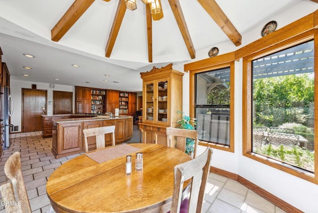 dining area featuring plenty of natural light, lofted ceiling with beams, sink, and ceiling fan