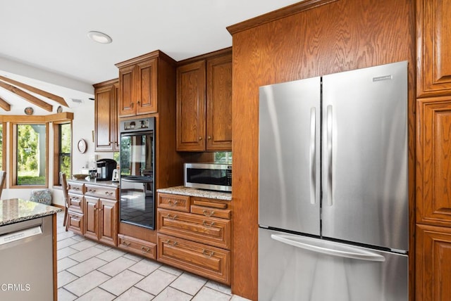 kitchen with light stone countertops and appliances with stainless steel finishes