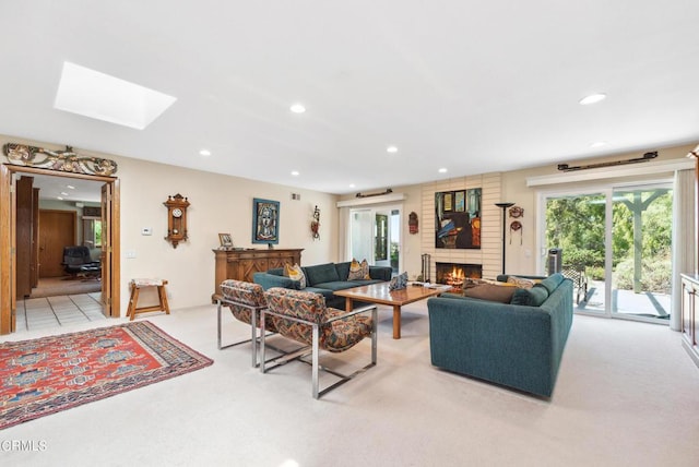 carpeted living room featuring a fireplace and a skylight