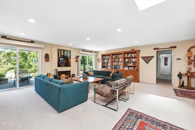 living room featuring a fireplace, a healthy amount of sunlight, and light carpet