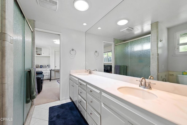 bathroom with tile patterned flooring, vanity, and a shower with door