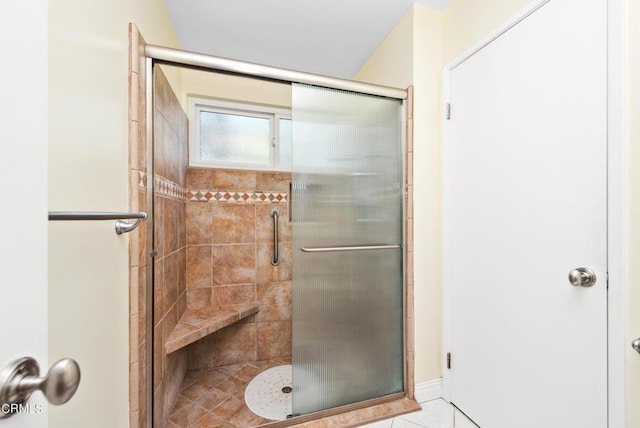 bathroom with tile patterned flooring and a shower with door