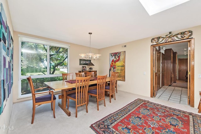 dining room featuring a chandelier, light colored carpet, and a skylight