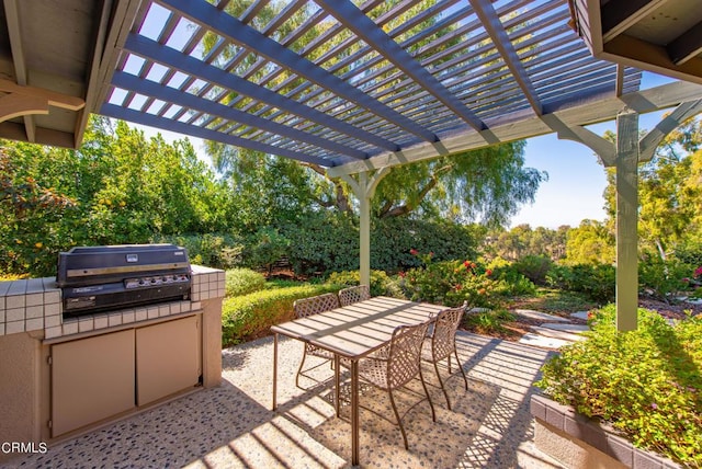 view of patio with an outdoor kitchen, a pergola, and a grill