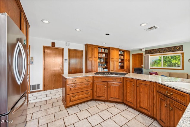 kitchen with kitchen peninsula, light stone counters, and stainless steel appliances