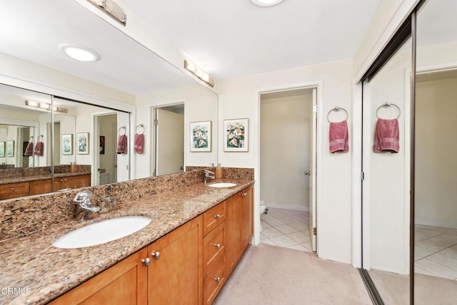 bathroom featuring toilet, vanity, and tile patterned floors