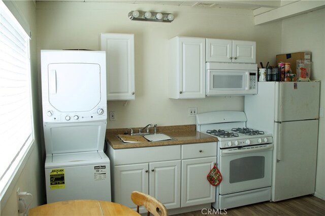 kitchen featuring white cabinets, white appliances, and stacked washing maching and dryer