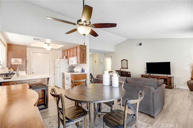 dining area featuring light hardwood / wood-style floors, lofted ceiling, ceiling fan, and sink