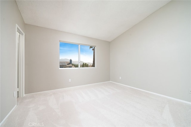 carpeted empty room with a textured ceiling and vaulted ceiling