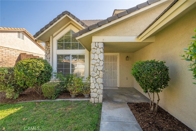 doorway to property featuring a lawn