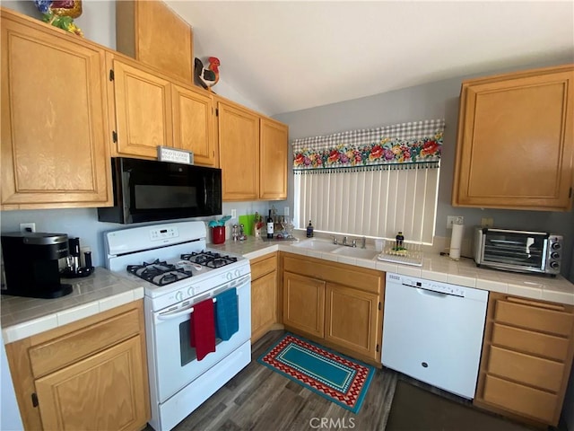 kitchen featuring tile countertops, sink, dark wood-type flooring, and white appliances