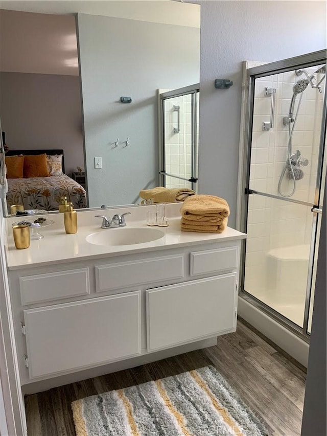 bathroom featuring hardwood / wood-style floors, vanity, and walk in shower