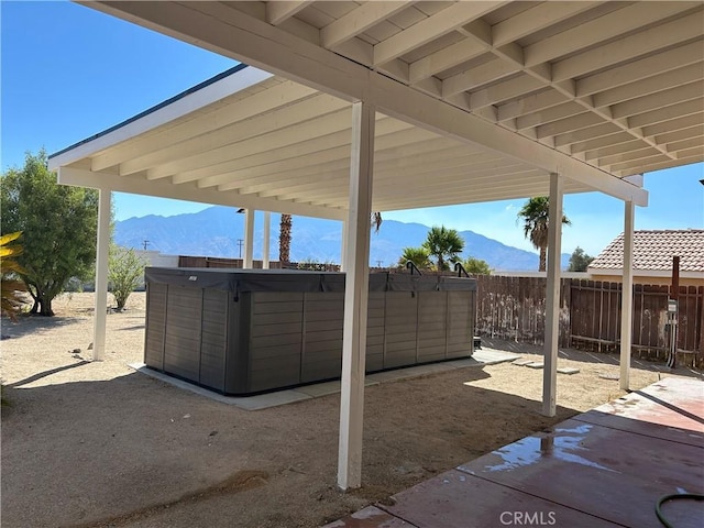 view of patio / terrace featuring a mountain view and a hot tub