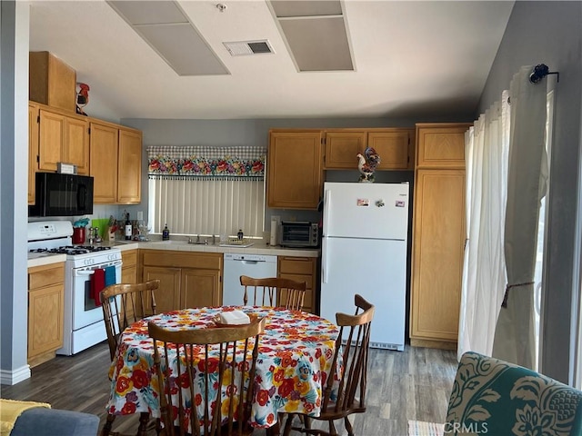 kitchen featuring white appliances, vaulted ceiling, and dark wood-type flooring