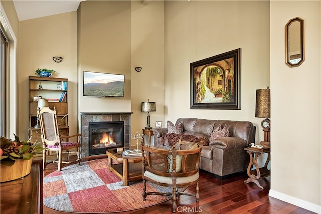 living room featuring a tiled fireplace and dark hardwood / wood-style floors