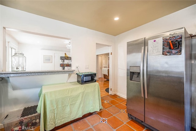 kitchen featuring tile patterned flooring and stainless steel refrigerator with ice dispenser