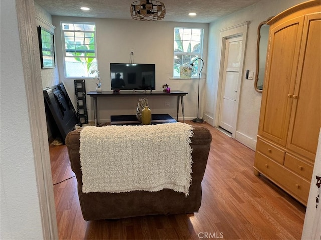 living room with light wood-type flooring and a textured ceiling