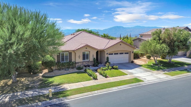 view of front of house with a garage, a mountain view, and a front yard