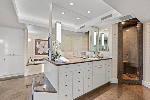 bathroom featuring vanity, a raised ceiling, and shower with separate bathtub