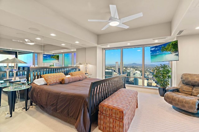 carpeted bedroom with ceiling fan and multiple windows