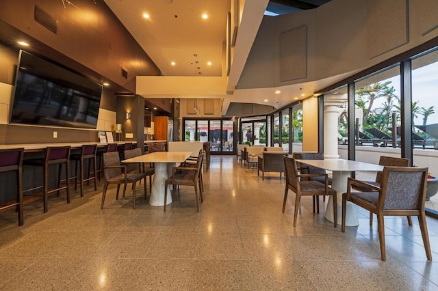 dining area featuring a towering ceiling