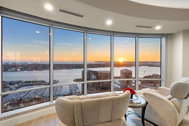 living room with a water view and hardwood / wood-style flooring