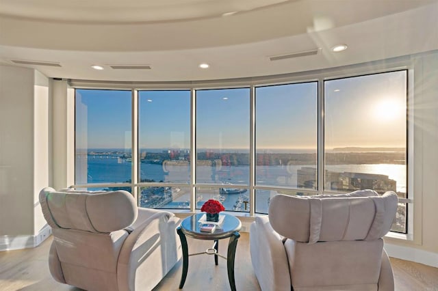 sitting room with light hardwood / wood-style floors and a water view