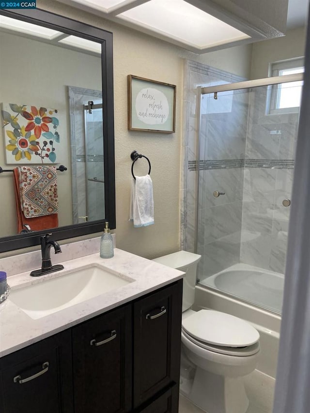 full bathroom with shower / bath combination with glass door, vanity, and toilet