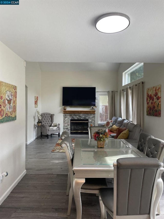 dining area featuring a fireplace, dark hardwood / wood-style flooring, and vaulted ceiling