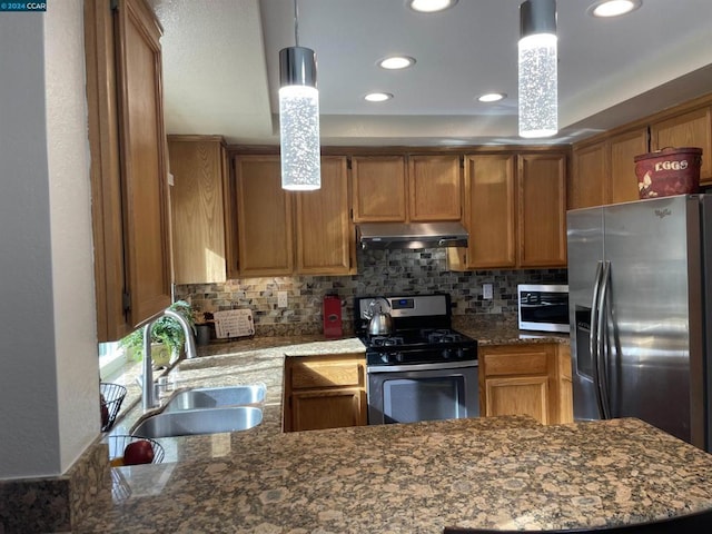 kitchen with backsplash, dark stone counters, stainless steel appliances, sink, and pendant lighting