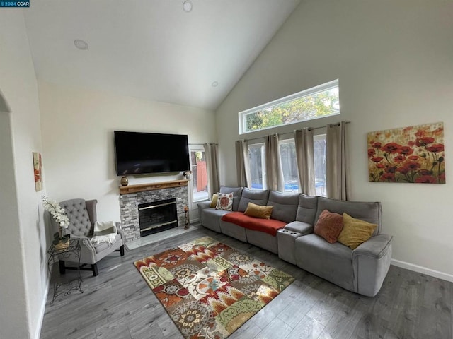 living room featuring hardwood / wood-style flooring, a fireplace, and high vaulted ceiling