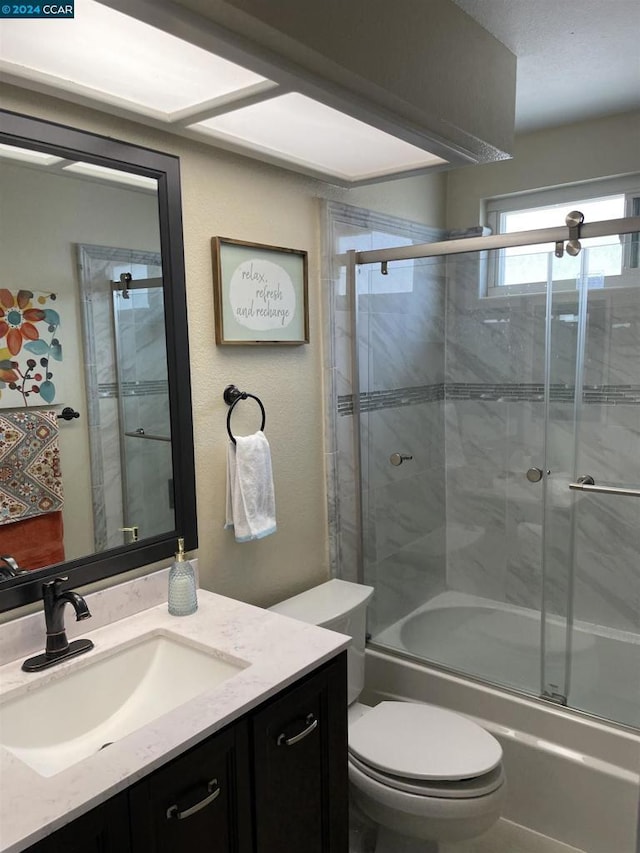 full bathroom featuring vanity, toilet, and bath / shower combo with glass door