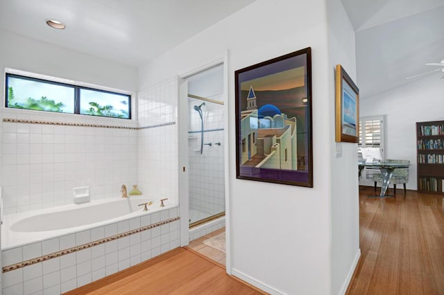 bathroom featuring ceiling fan, a healthy amount of sunlight, wood-type flooring, and plus walk in shower